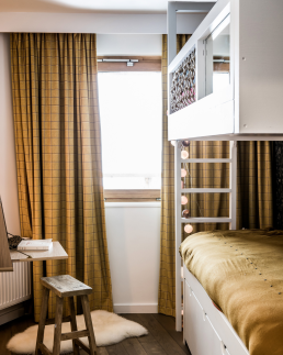 Petit chalet int&eacute;rieur design chambre enfant avec lit superpos&eacute; blanc, rideaux moutarde &agrave; carreaux et coin bureau minimaliste en bois.