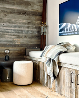 Am&eacute;nagement coin d&eacute;tente de petit chalet int&eacute;rieur, mur en bois vieilli, banquette avec plaids douillets et rangements int&eacute;gr&eacute;s.