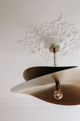 Rosace haussmannienne d&eacute;corative associ&eacute;e &agrave; une suspension contemporaine, exemple de modernisation par l&rsquo;&eacute;clairage