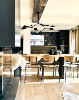 Cuisine ouverte sur salle &agrave; manger dans un chalet r&eacute;nov&eacute; &ndash; m&eacute;lange bois clair, m&eacute;tal noir et suspension design