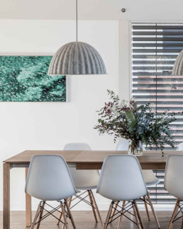 Rénovation de locaux professionnels : salle de réunion avec table en bois, chaises design et suspension en feutre par Marque de Fabrik