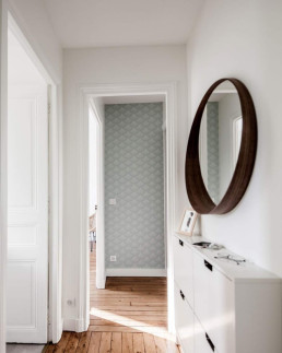 Couloir petit appartement avec miroir rond bois et papier peint écailles - Marque de Fabrik